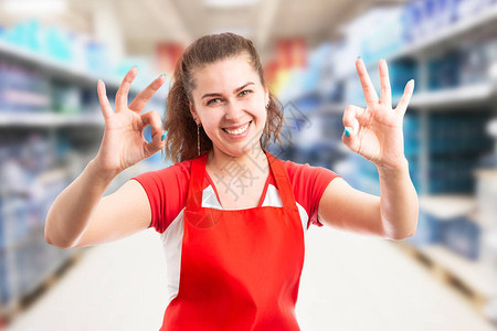 大卖场或超级市场的女员工用双手指和友好的表情图片