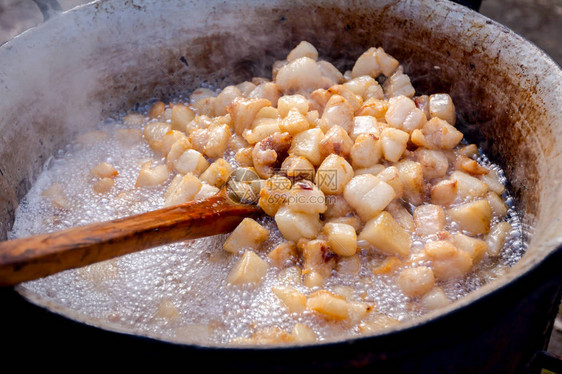 将新鲜猪肉脂肪和培根融化的传统方式在深层的铁酸图片