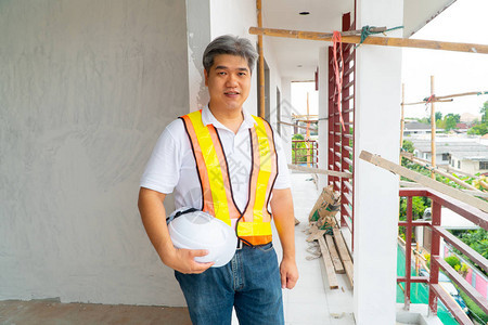 亚洲专业工程师在房屋建筑工地检查在建小屋图片