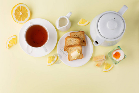 早餐桌有软煮鸡蛋脆煎烤面包和黄底图片