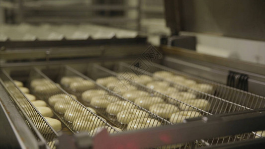 在工厂油炸圈饼的制备过程油炸面团糖果或甜点食品概念在面包店将甜图片