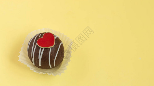 巧克力松饼有心脏的甜蛋糕在面黄背景图片