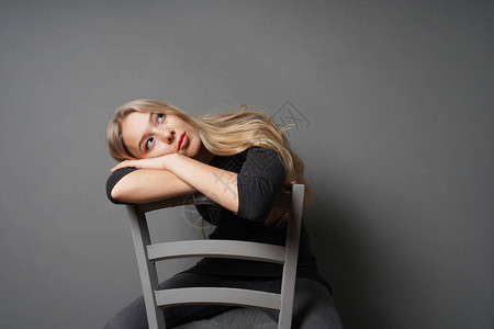 无聊的女跨坐在椅子上图片