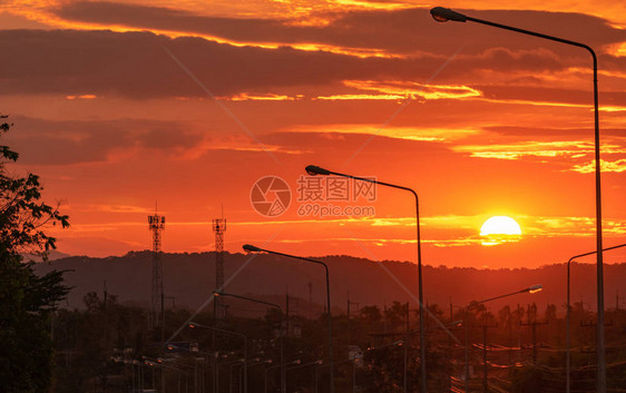 早上在山上的美丽日出从道路和电线杆和电缆线查看早上旅行之间的美丽场景大太阳早上在云图片