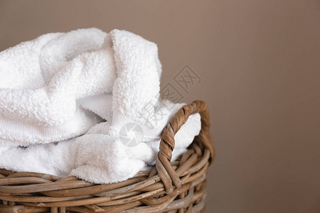 彩色背景上有脏毛巾的洗衣篮图片