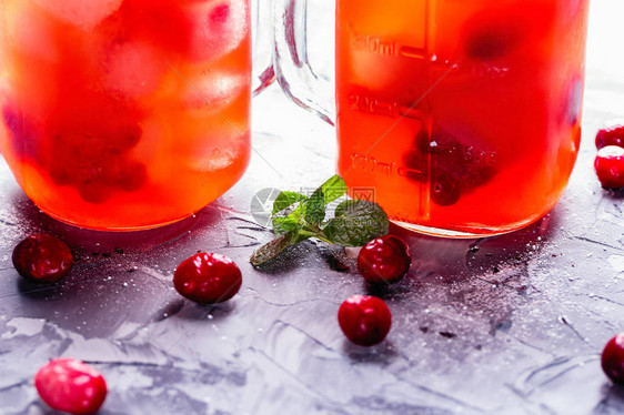 带小红莓柑橘和新鲜薄荷叶的自制冰水图片