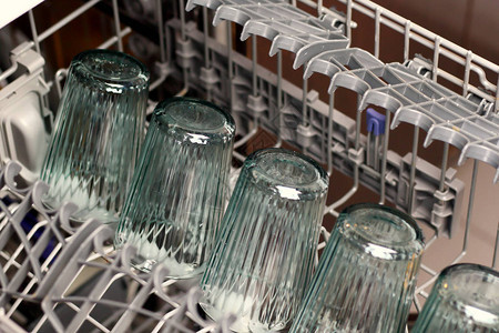 带玻璃杯和白瓷杯的洗碗机在洗碗机中洗碗图片
