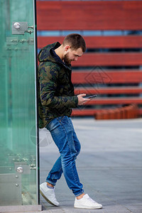 年轻人在城市街的手机上发短信波图片