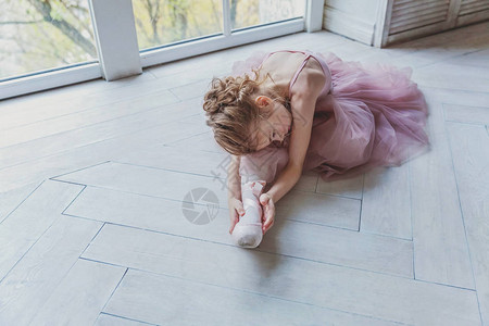 舞蹈课上的年轻古典芭蕾舞演员女孩美丽优雅的芭蕾舞女演员在白光大厅里穿着粉色短裙图片