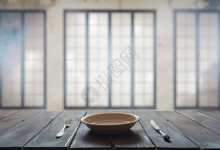 在有大窗户的房间的旧木制桌子上用叉子刀和图片