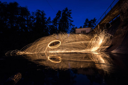 迪士尼烟花燃烧的钢丝绒在旧水坝附近旋转旋转的钢丝绒发出阵炽热的火花长期接触水面背景