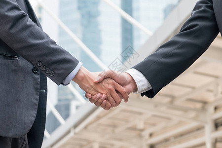 商人与该市伙伴关系的握手合作图片