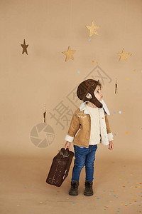 梦想和旅行的概念带玩具飞机和手提箱的飞行员孩子在米图片