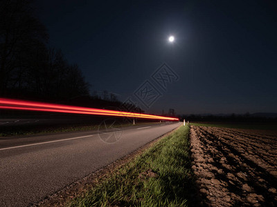 一辆过往的汽车照亮的乡村公路图片