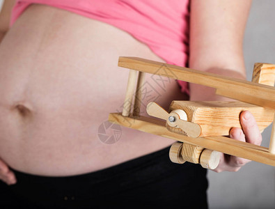 年龄在30至35岁之间的年轻怀孕妇女拥有木制飞机图片