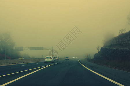 雾中高速公路上的交通晚上在城市高速公路上的汽车在恶劣的天气条件下日落时能见度差用复古电影图片
