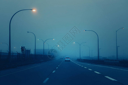 在神秘的雾烟中的公路晚上在美国城市高速公路上的汽车在恶劣的天气条件下能见度差用时髦滤镜调色图片