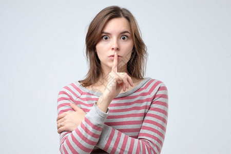 照片  |嘘嘘,噤声照片  |人,手势秘密美丽的轻女人握着手指她的嘴唇