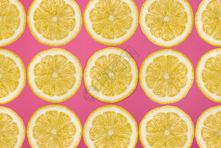 由粉红色背景的新鲜柠檬切片高空视图平板木水果背景图片