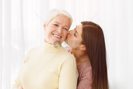 年幼的女儿亲吻长母亲的脸图片