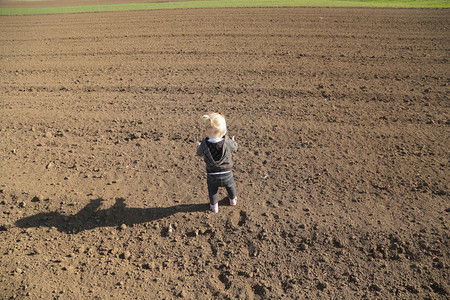 在平地上玩泥土的可爱女婴图片