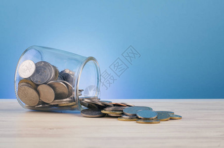 财务和储蓄资金概念木制办公桌玻璃罐图片