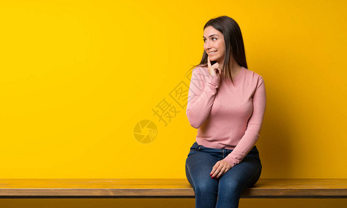 坐在桌子上思考想法的年轻女士图片