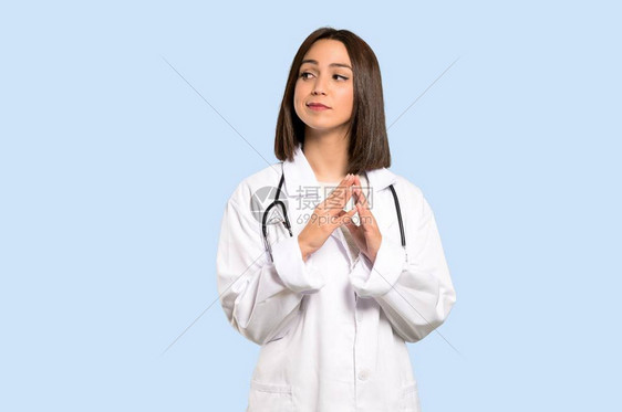 年轻女医生以孤立的蓝色背景图片
