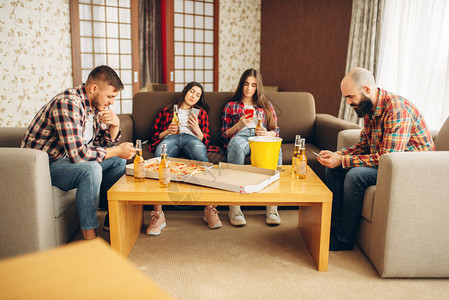 朋友在无聊的家庭聚会上用手机聊天图片