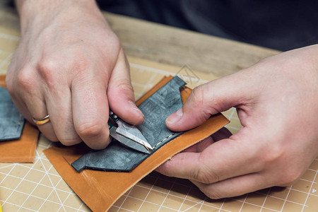 在车间制作皮革钱包的人皮革制品手工图片