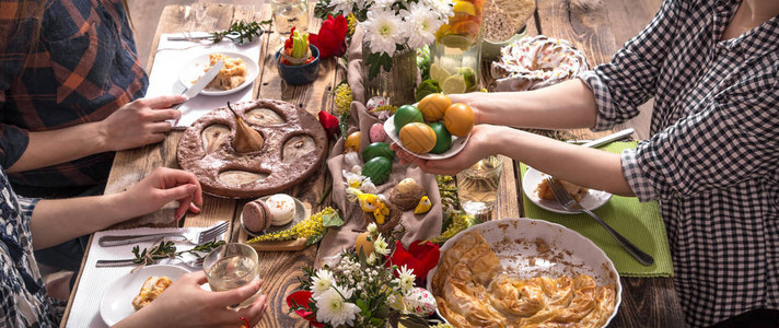 家庭假期的朋友或家人在复活节彩蛋的节日餐桌旁庆图片