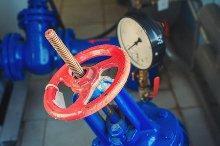 气体供应或供暖管道上的红色阀门和压力传感器图片