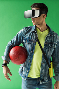 身穿虚拟现实头盔在绿屏上打篮球的图片