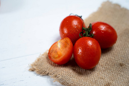 白色木背景上的新鲜樱桃番茄图片