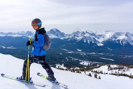 年轻的滑雪者站在加拿大艾伯塔省落基山脉的路易图片