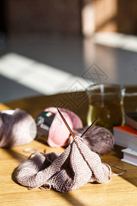 桌子上放着带纱线的针织和织质感的毛衣帽子围巾图片