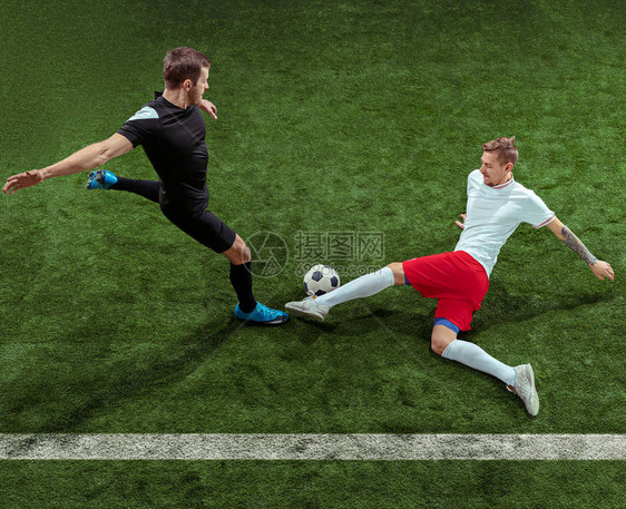 足球运动员在绿草背景下抢球职业男子足球运动员在体育场运动适合跳跃的人在游戏中的动作图片