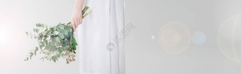 身着裙子在白衣上拿着鲜花的女图片