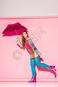 穿成格子装的年轻女人拿着雨伞背景图片