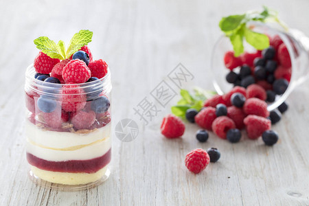 草莓和蓝莓甜点芝士蛋糕小饼老鼠放在玻璃罐里图片
