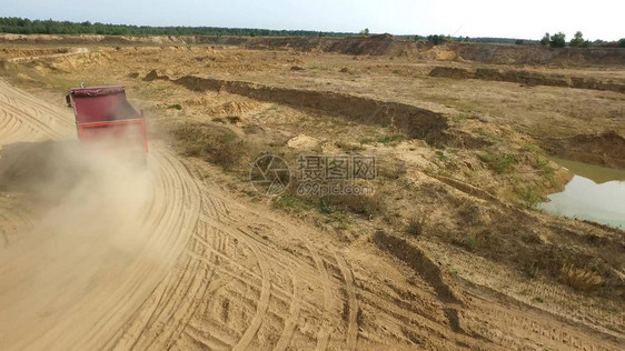 露天矿路上的自卸车场景自卸卡车在乡村粘土路采石场上行驶的顶部视图图片