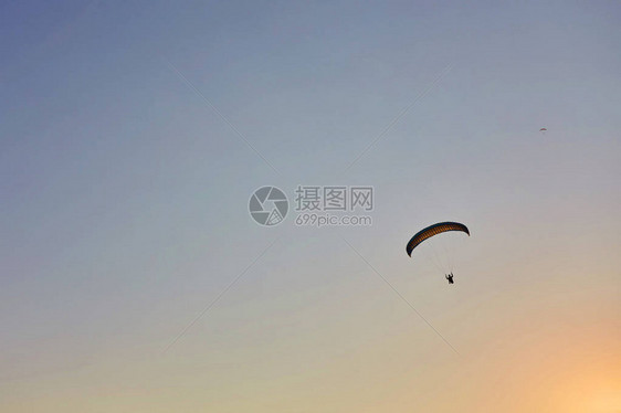 滑翔伞剪影以美丽温暖的日落色彩飞过迷雾笼罩的山谷充满自由的运动活跃壁纸背景与空间图片