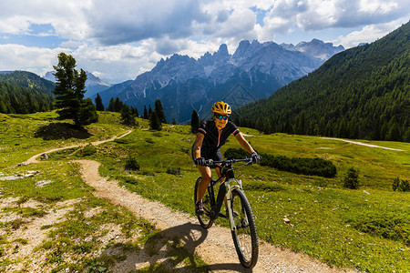在山路上骑电动自行车的女人在多洛米蒂山脉景观中骑自行车的女人骑自行车emtb耐力赛道图片
