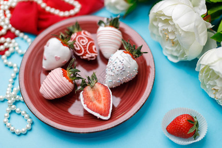 花珍珠红围巾和草莓在绿宝石背景的白图片