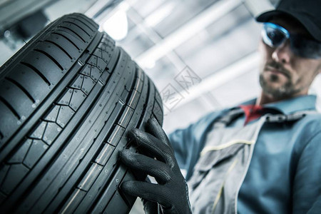 汽车工人用新轮胎更换汽车轮胎图片