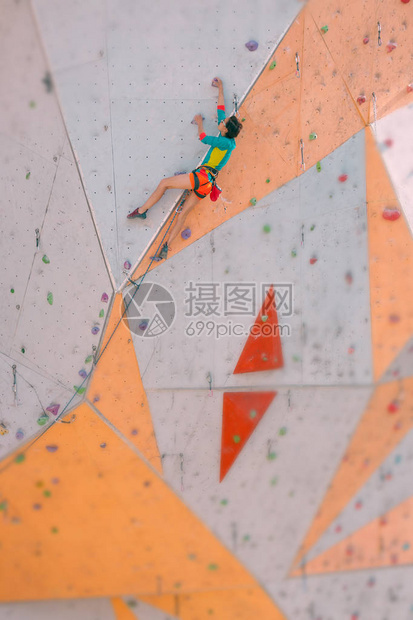 在城市攀岩馆训练一个强壮的女人在造地形上攀登路线参与体育运图片