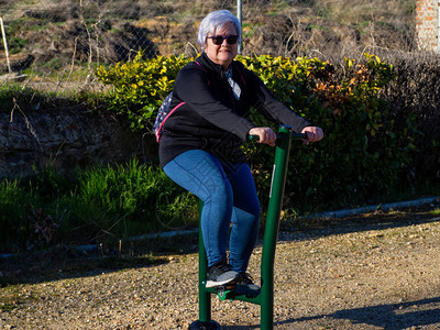 一位白发老妇在生物健康公园练习体操图片