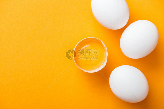 粉碎鸡蛋的顶部视图全白蛋中以亮橙图片