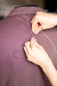 年轻女裁缝手用针头和白线缝补新夹克或图片