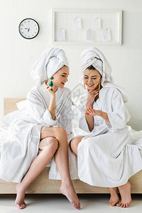 戴耳环浴袍和头部毛巾的时装笑脸女孩图片